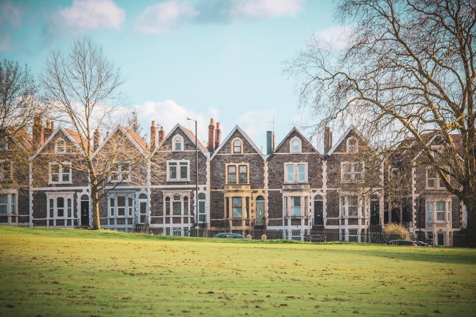 A row of Victorian terraced houses on Sussex Gardens featuring brick and rendered facades, with some properties painted in pastel blue and cream. The houses have small front gardens enclosed by low wa